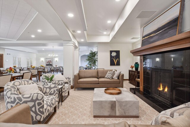 7100 Metro Blvd Unit 206, Edina, MN 55439 - living area featuring visible vents, decorative columns, light carpet, a warm lit fireplace, and a tray ceiling