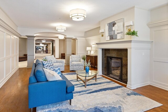 7100 Metro Blvd Unit 206, Edina, MN 55439 - living room with a decorative wall, arched walkways, a tiled fireplace, wood finished floors, and ornate columns