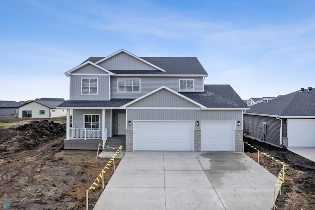 3187 Archer Pl S, Fargo, ND 58104 - view of front facade with a porch, a shingled roof, driveway, and stone siding
