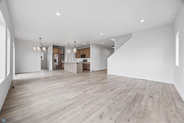 3187 Archer Pl S, Fargo, ND 58104 - unfurnished living room featuring light wood-style floors, recessed lighting, a chandelier, a sink, and baseboards