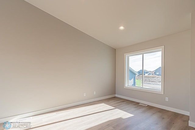 empty room featuring recessed lighting, visible vents, baseboards, and wood finished floors