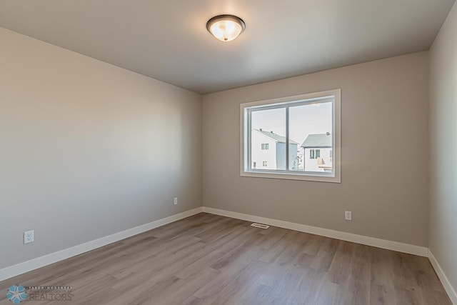 empty room featuring wood finished floors and baseboards