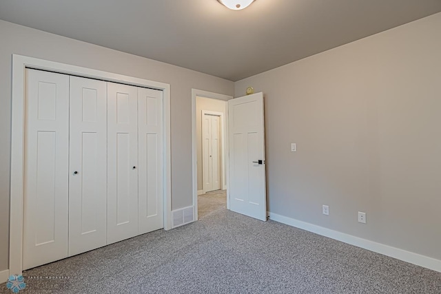 unfurnished bedroom with a closet, carpet flooring, and baseboards