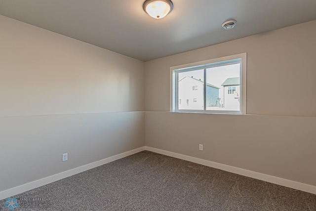 unfurnished room featuring dark carpet, baseboards, and visible vents