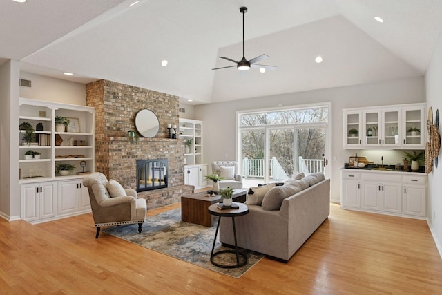 7604 Delaney Blvd, Edina, MN 55439 - living room featuring visible vents, ceiling fan, light wood-style flooring, and a brick fireplace