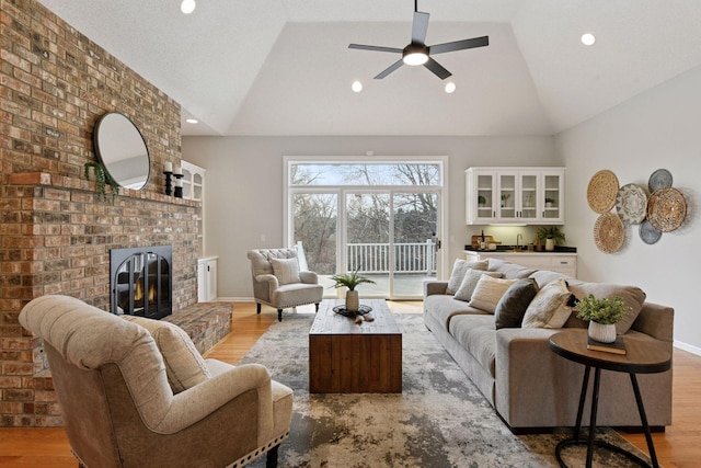 7604 Delaney Blvd, Edina, MN 55439 - living area featuring a brick fireplace, ceiling fan, light wood-type flooring, vaulted ceiling, and indoor bar