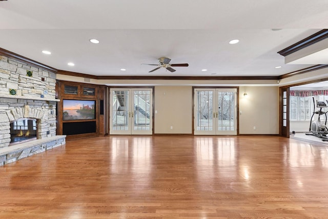 7604 Delaney Blvd, Edina, MN 55439 - unfurnished living room with ornamental molding, a ceiling fan, light wood finished floors, a fireplace, and french doors