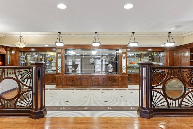 7604 Delaney Blvd, Edina, MN 55439 - bar area with ornamental molding, wood finished floors, and decorative light fixtures