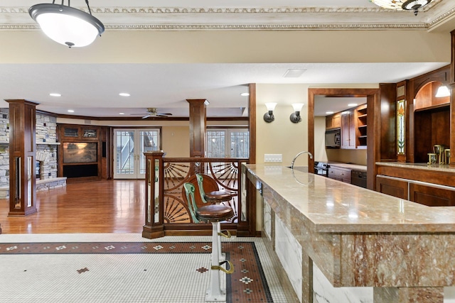 7604 Delaney Blvd, Edina, MN 55439 - kitchen featuring black microwave, decorative columns, light stone counters, wood finished floors, and recessed lighting