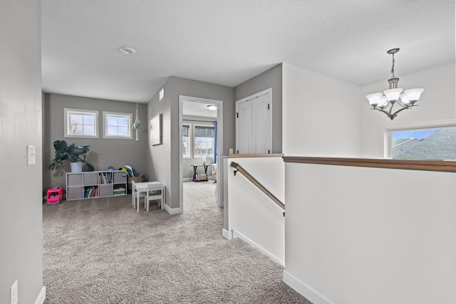 5836 Radford Ave NE, Otsego, MN 55374 - corridor with carpet, an upstairs landing, baseboards, a chandelier, and a textured ceiling