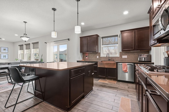 5836 Radford Ave NE, Otsego, MN 55374 - kitchen featuring recessed lighting, stainless steel appliances, a sink, a kitchen island, and decorative backsplash