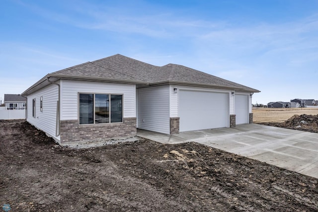 10218 73rd St S, Horace, ND 58047 - view of side of property with brick siding, an attached garage, concrete driveway, and roof with shingles