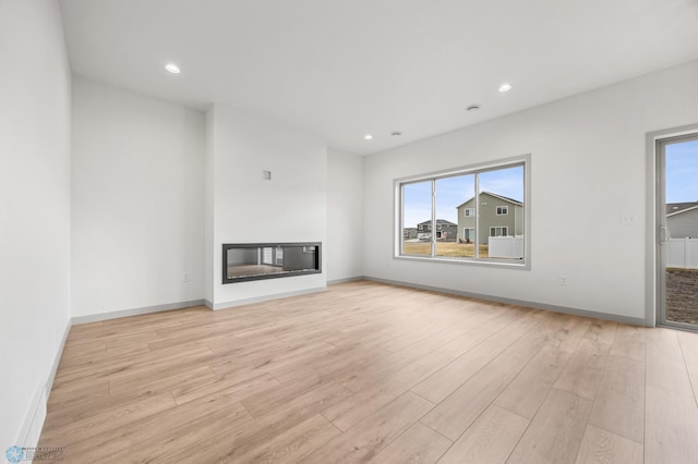 10218 73rd St S, Horace, ND 58047 - unfurnished living room featuring recessed lighting, a glass covered fireplace, wood finished floors, and baseboards