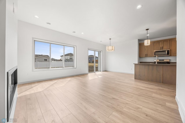 10218 73rd St S, Horace, ND 58047 - unfurnished living room with a fireplace, light wood-type flooring, baseboards, and recessed lighting