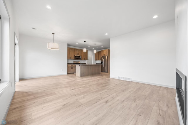 10218 73rd St S, Horace, ND 58047 - unfurnished living room featuring baseboards, light wood finished floors, visible vents, and recessed lighting