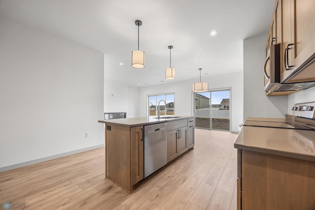 10218 73rd St S, Horace, ND 58047 - kitchen featuring stainless steel appliances, a sink, pendant lighting, a kitchen island with sink, and light wood-style flooring