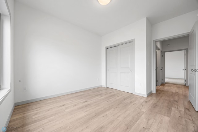 10218 73rd St S, Horace, ND 58047 - unfurnished bedroom with baseboards, a closet, and light wood-style flooring