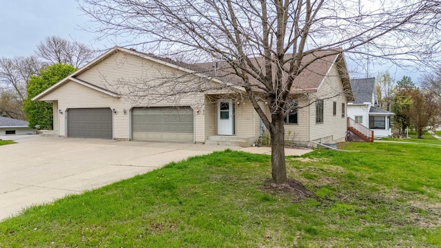 view of front of house with an attached garage, concrete driveway, and a front lawn