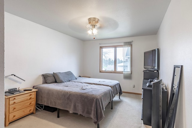 bedroom with light carpet, baseboards, and a ceiling fan