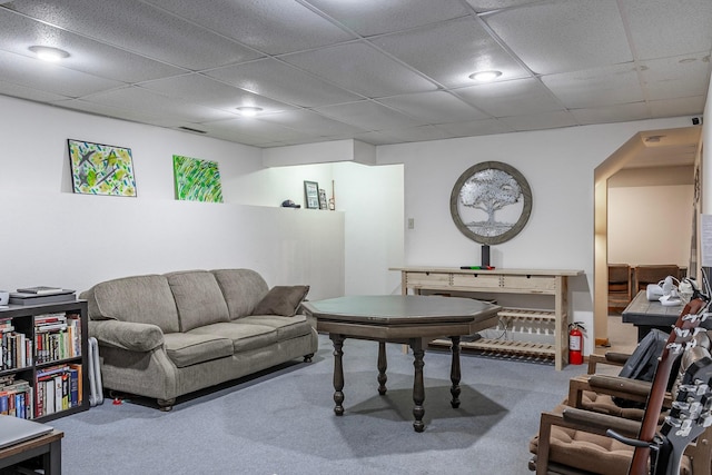 carpeted living room with a drop ceiling