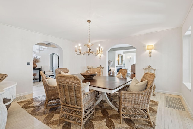 4232 Fremont Ave S, Minneapolis, MN 55409 - dining area with arched walkways, a chandelier, and light wood-style floors