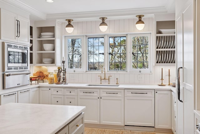 4232 Fremont Ave S, Minneapolis, MN 55409 - kitchen featuring a warming drawer, stainless steel microwave, ornamental molding, light countertops, and white cabinets