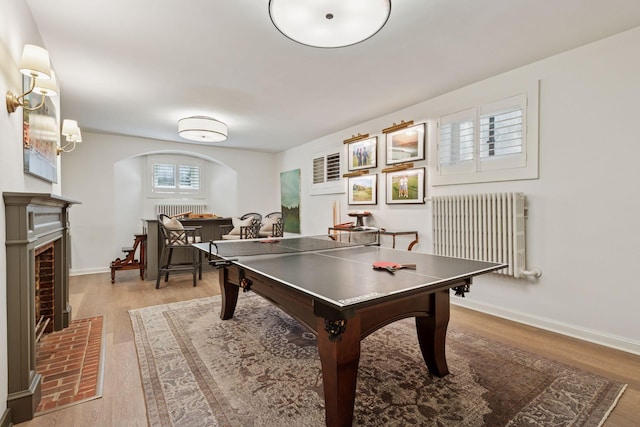 4232 Fremont Ave S, Minneapolis, MN 55409 - game room featuring radiator, arched walkways, wood finished floors, and a fireplace