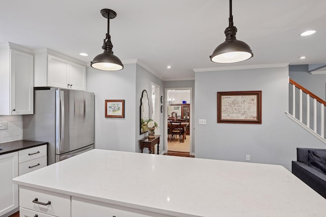 kitchen with freestanding refrigerator, recessed lighting, crown molding, and white cabinetry