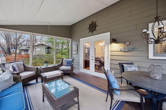 sunroom / solarium with an inviting chandelier, outdoor dining space, outdoor lounge area, and french doors