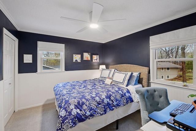 carpeted bedroom featuring crown molding, baseboards, and ceiling fan
