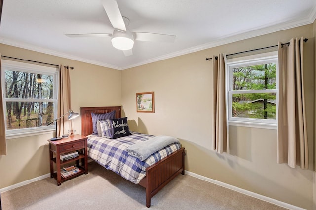 carpeted bedroom featuring crown molding, baseboards, and ceiling fan