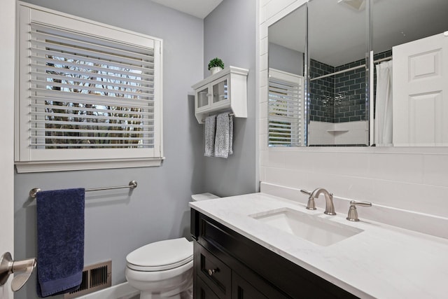 bathroom with backsplash, visible vents, a tile shower, vanity, and toilet