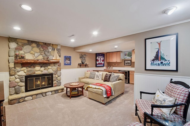 living room featuring visible vents, crown molding, beverage cooler, light colored carpet, and a wainscoted wall
