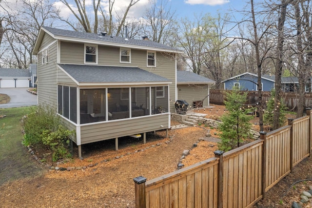 rear view of property with a shingled roof, a sunroom, fence private yard, and a chimney