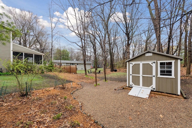 view of yard with an outbuilding, a sunroom, and a shed