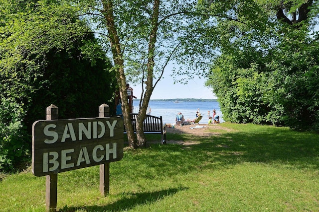 view of home's community with a lawn and a water view