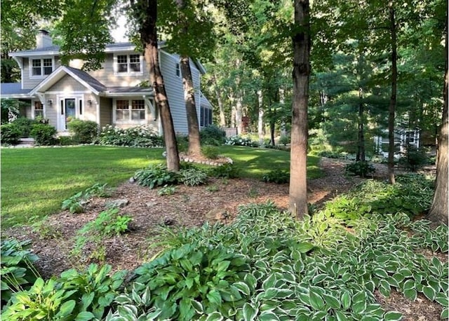 view of front facade featuring a front lawn and a chimney