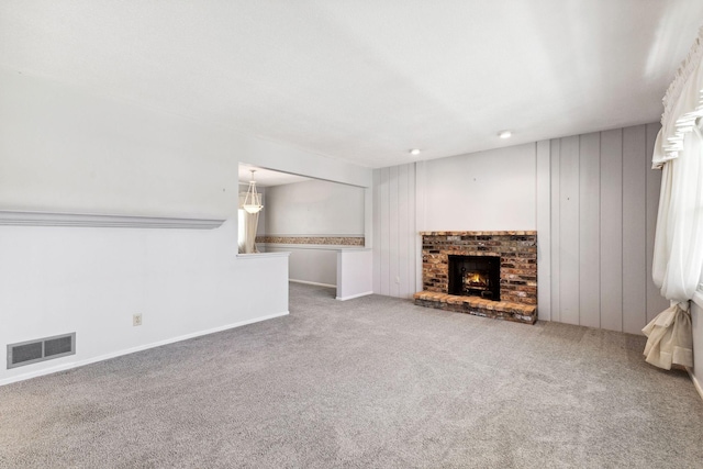 unfurnished living room featuring visible vents, carpet flooring, and a fireplace