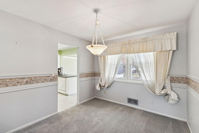 unfurnished dining area featuring visible vents and light carpet