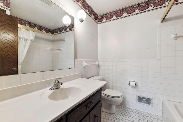 bathroom with visible vents, vanity, toilet, tile walls, and tile patterned floors