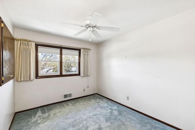 carpeted empty room with a ceiling fan, baseboards, and visible vents