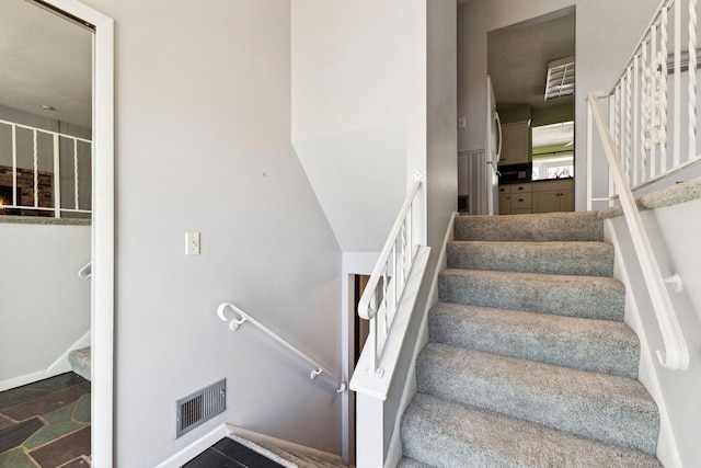 staircase with baseboards and visible vents