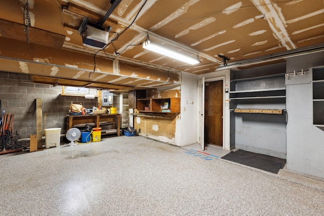 garage featuring a garage door opener and concrete block wall