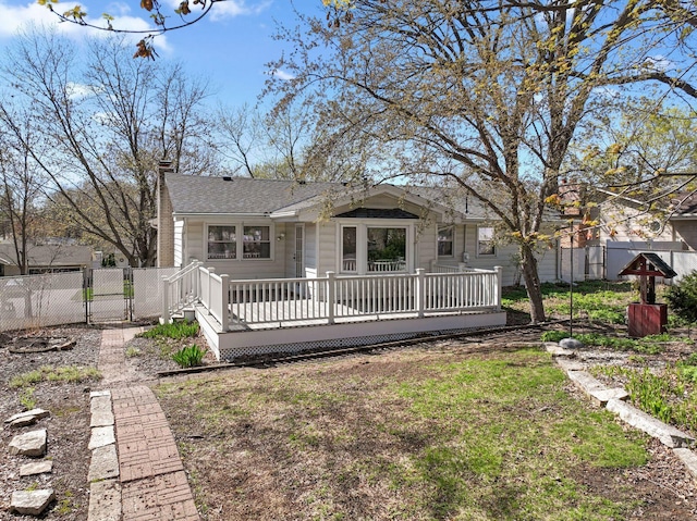 view of front of house with fence, a wooden deck, a chimney, and roof with shingles