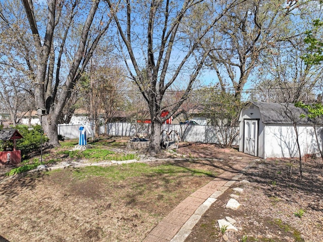 view of yard featuring a storage shed, an outdoor structure, and a fenced backyard