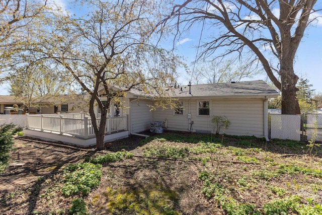 back of property with a wooden deck and fence