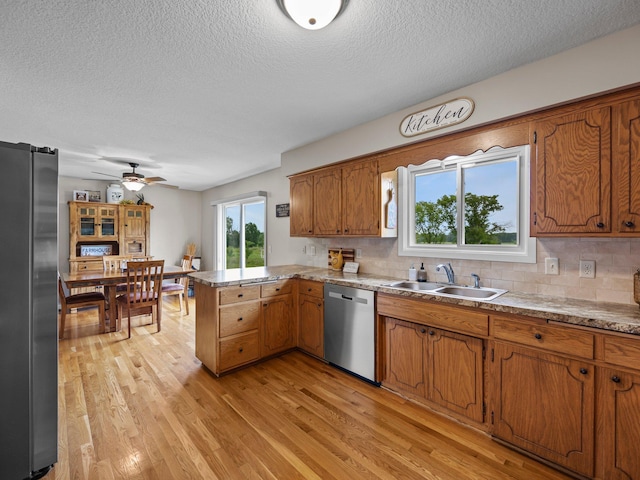 26635 Variolite St NW, Stanford Twp, MN 55070 - kitchen with appliances with stainless steel finishes, a textured ceiling, a peninsula, brown cabinets, and light wood finished floors