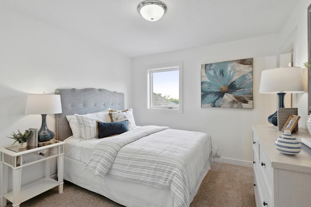 bedroom with light colored carpet and baseboards