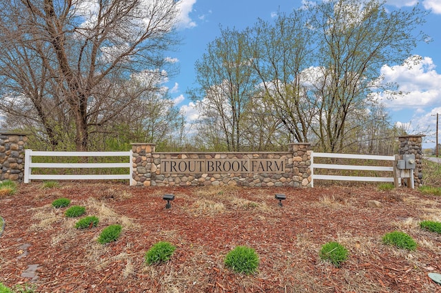 community / neighborhood sign featuring fence