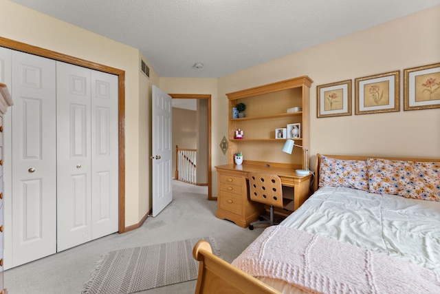 bedroom with baseboards, visible vents, light carpet, and a closet